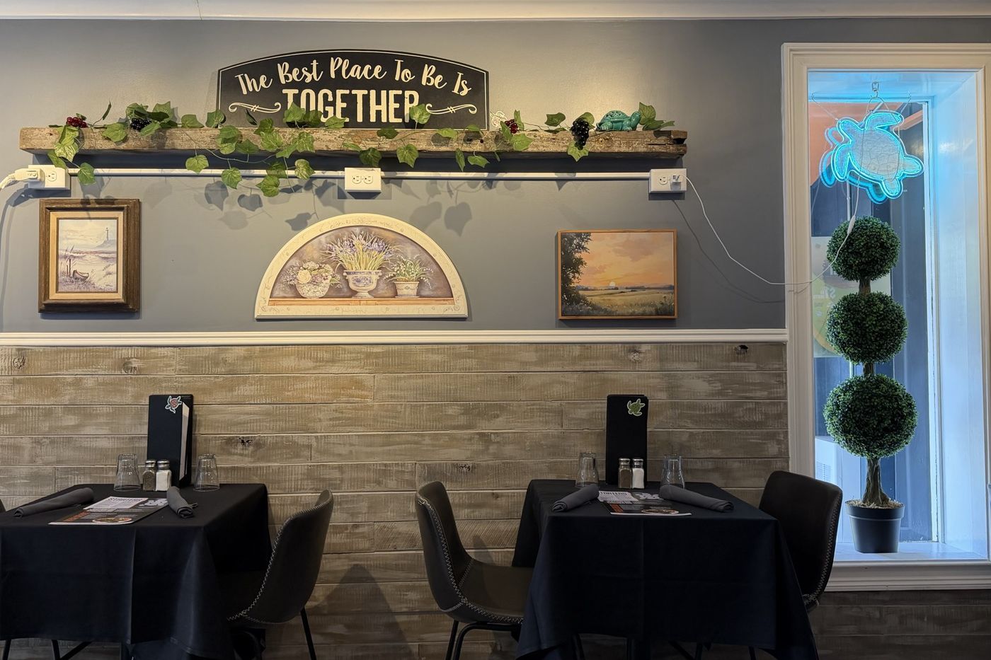 A sign reading "The Best Place To Be Is Together" above the dining room.
